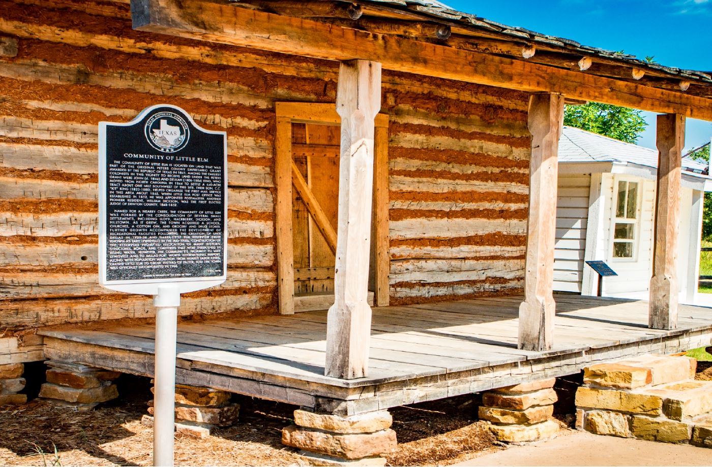 A cabin with a City of Little Elm plaque.