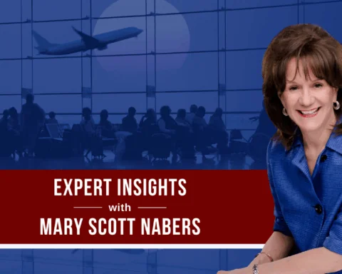 Mary Scott Nabers smiles for a professional headshot in front of a blue graphic of an airport