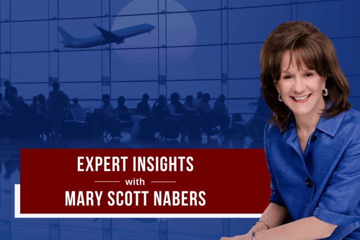 Mary Scott Nabers smiles for a professional headshot in front of a blue graphic of an airport