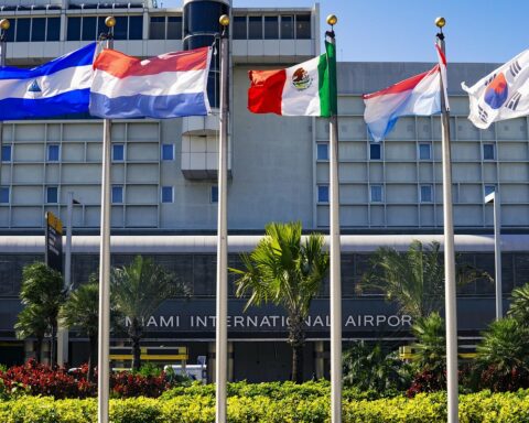Six international flags sit on flag poles in front of the Miami International Airport building in Miami.