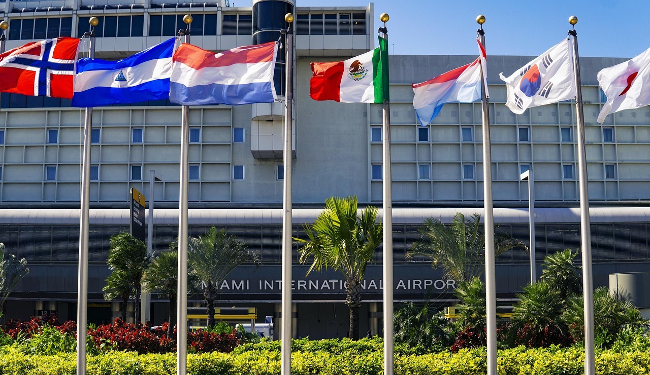 Six international flags sit on flag poles in front of the Miami International Airport building in Miami.