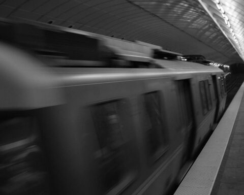 A train in the Massachusetts Bay Transportation Authority system blurs past the platform.