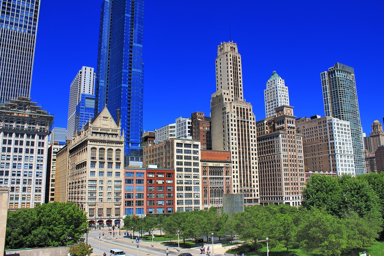 The Chicago skyline shines in the daylight with a clear blue sky in the background.