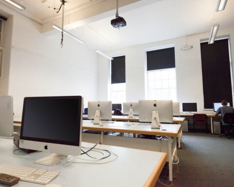 rows of computers at desks in a school classroom