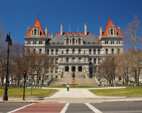 ny capitol building stands against a blue sky