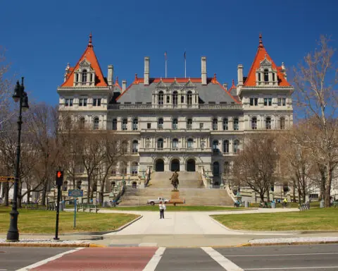 ny capitol building stands against a blue sky