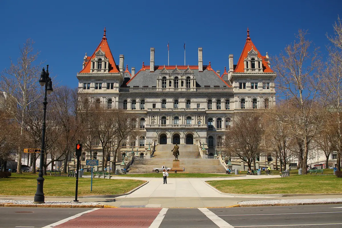 ny capitol building stands against a blue sky