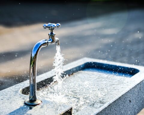 An outdoor water feature pours water into a fountain.