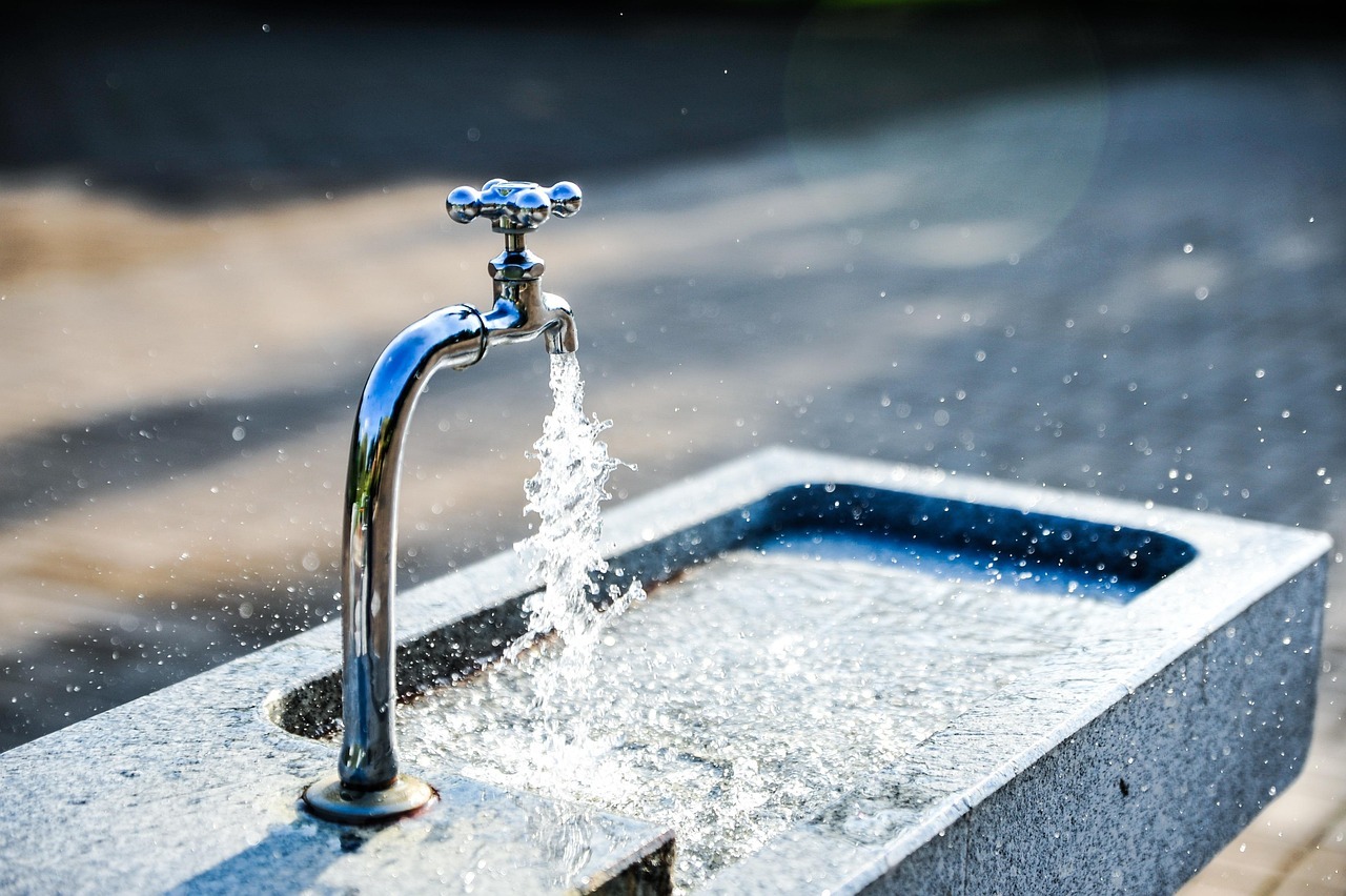An outdoor water feature pours water into a fountain.