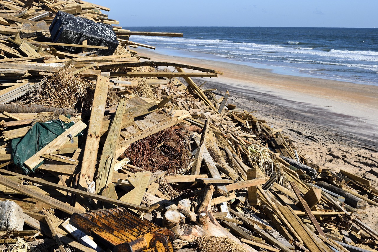 Garbage and debris are piled up alongside a beach concluding Hurricane Matthew.