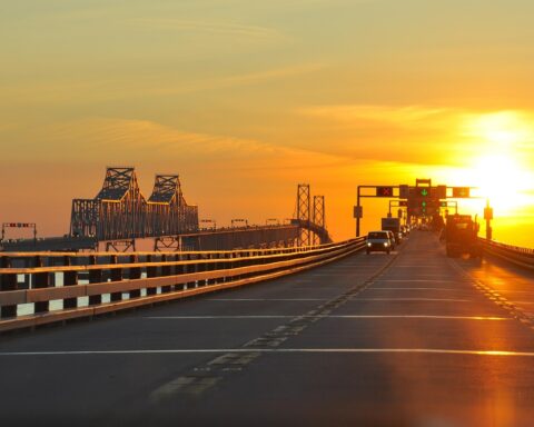 Traffic drives down a long elevated highway as the sun set behind the road in Maryland.