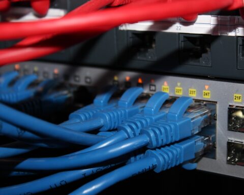 The image depicts a variety of blue and red cables plugged into an internet connection.