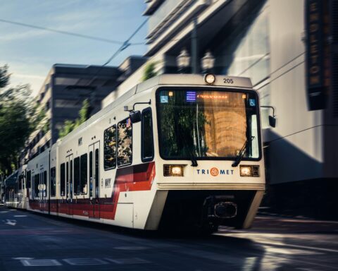 A TriMet train as pictured from the front as it passes in a corridor in Portland, Oregon.