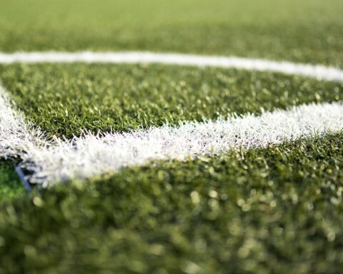 The image depicts the corner stripping of green turf field.