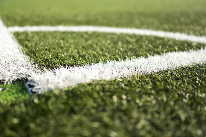 The image depicts the corner stripping of green turf field.