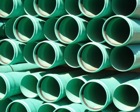 A bunch of green pipes stacked on each other.