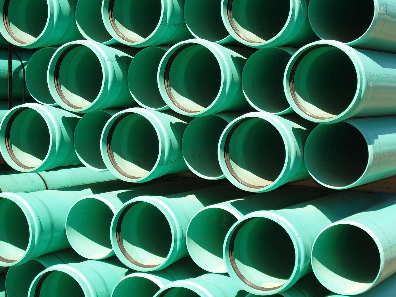 A bunch of green pipes stacked on each other.