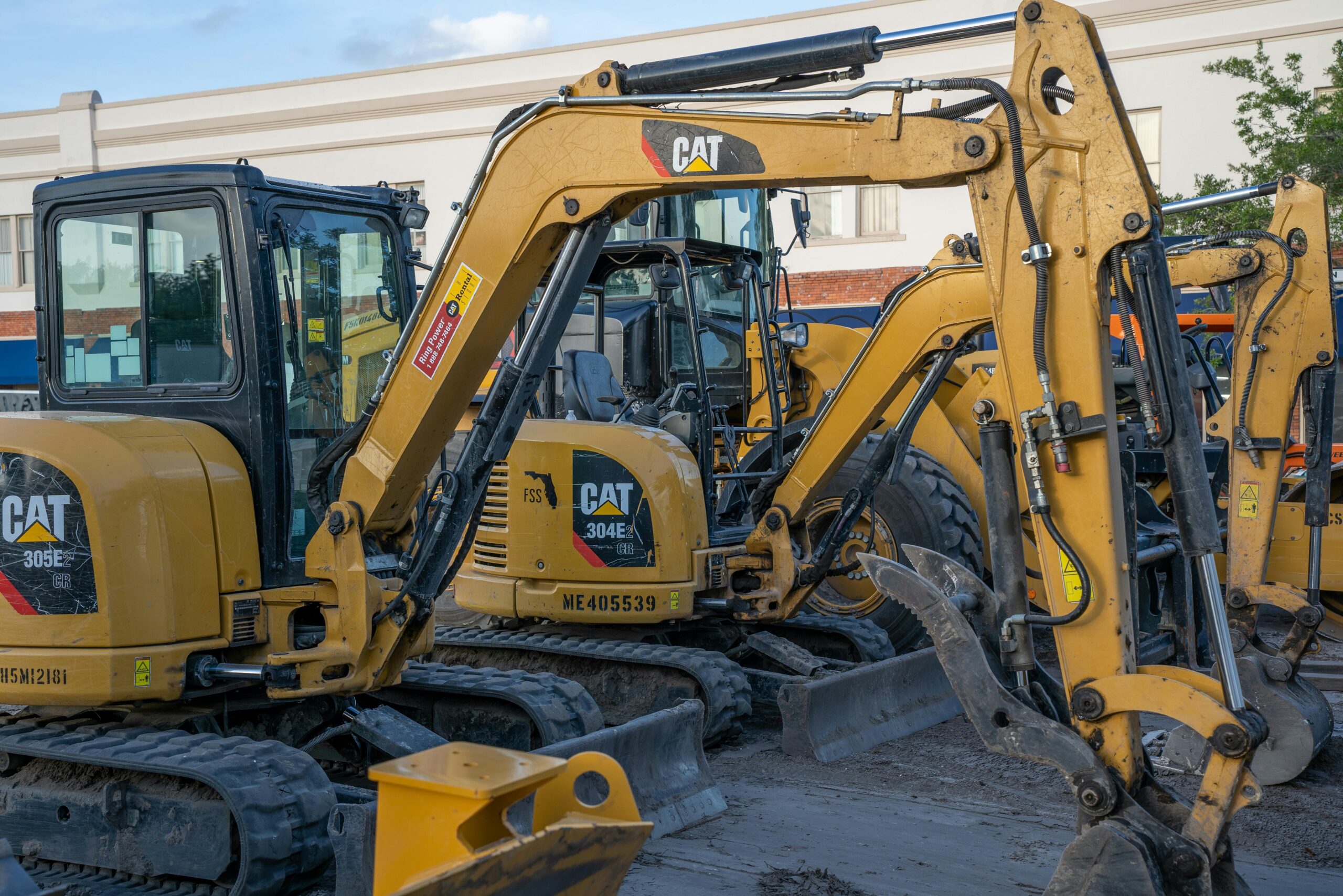 Several construction vehicles sit near one another on a construction site.