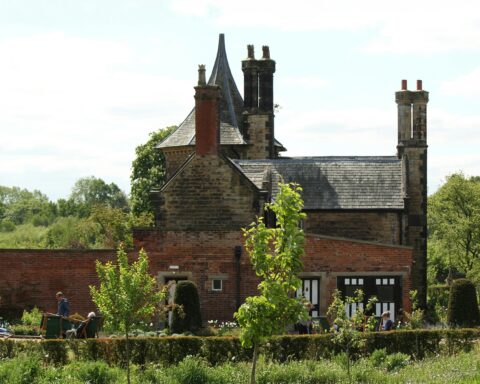 An old, historic building wrapped in greenery and vines.