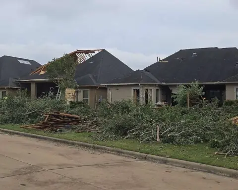 Disaster-damaged homes with broken trees and debris in Cypress near Houston, Texas.