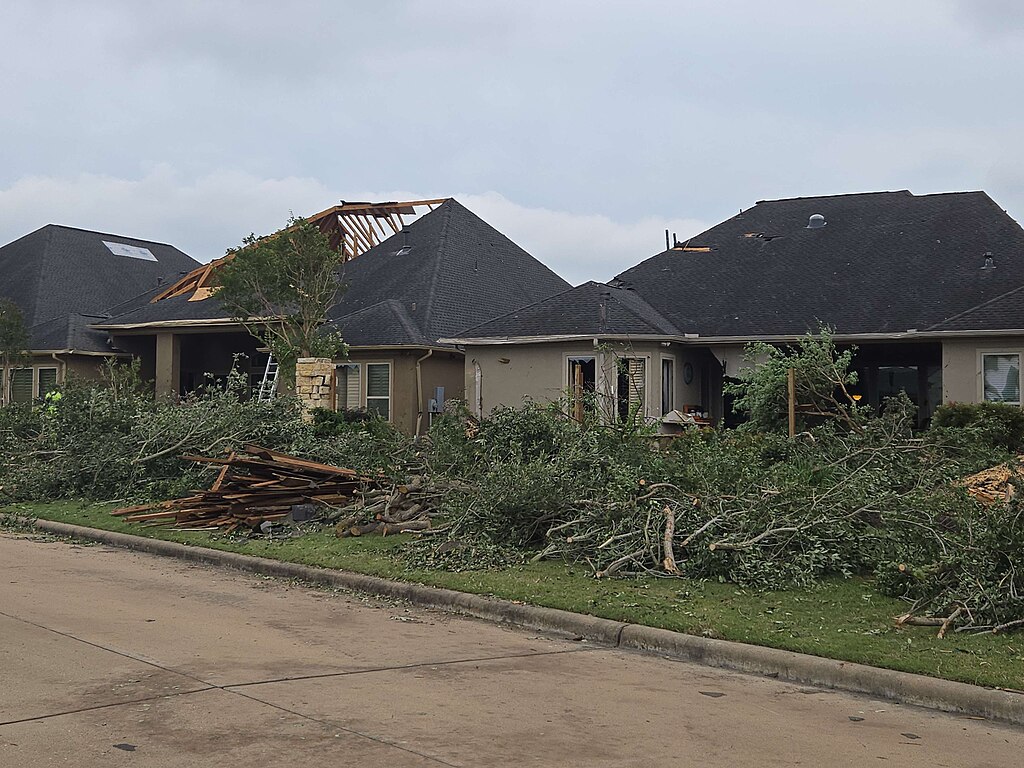 Disaster-damaged homes with broken trees and debris in Cypress near Houston, Texas.