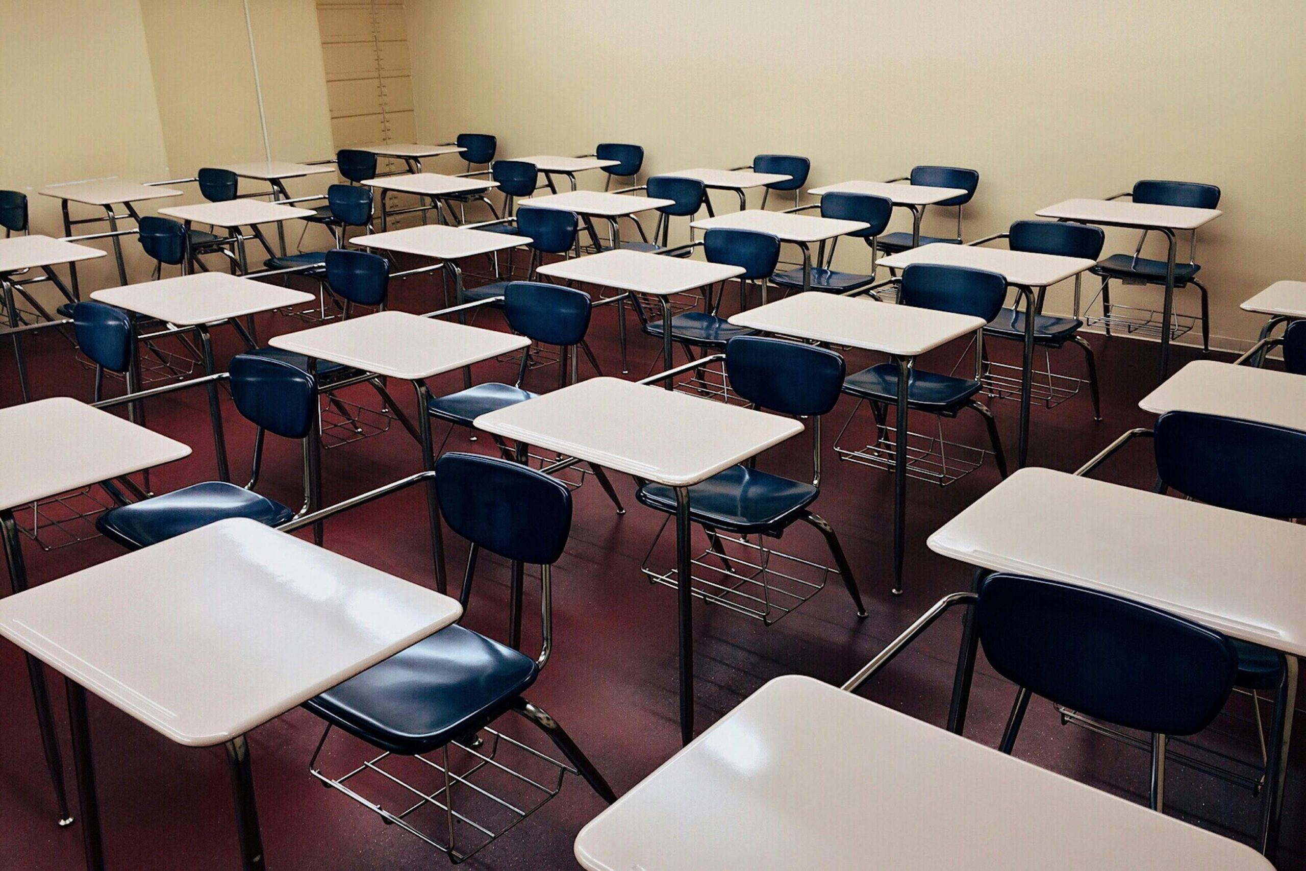 A classroom full of empty chairs and desks for students.