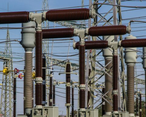 Several energy transformers before a blue sky.