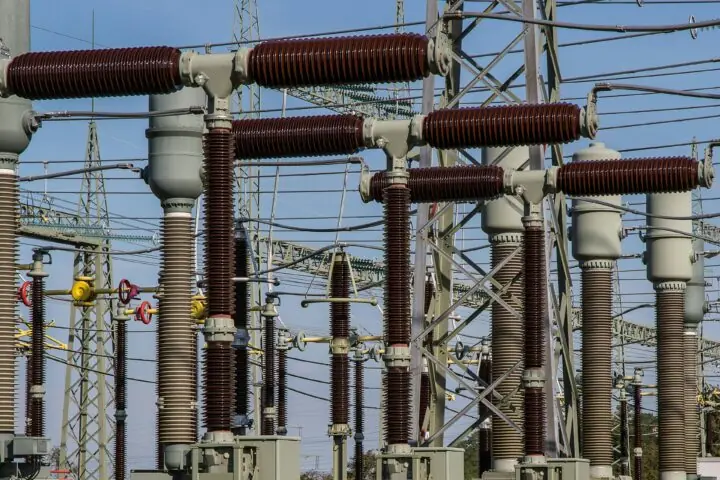 Several energy transformers before a blue sky.