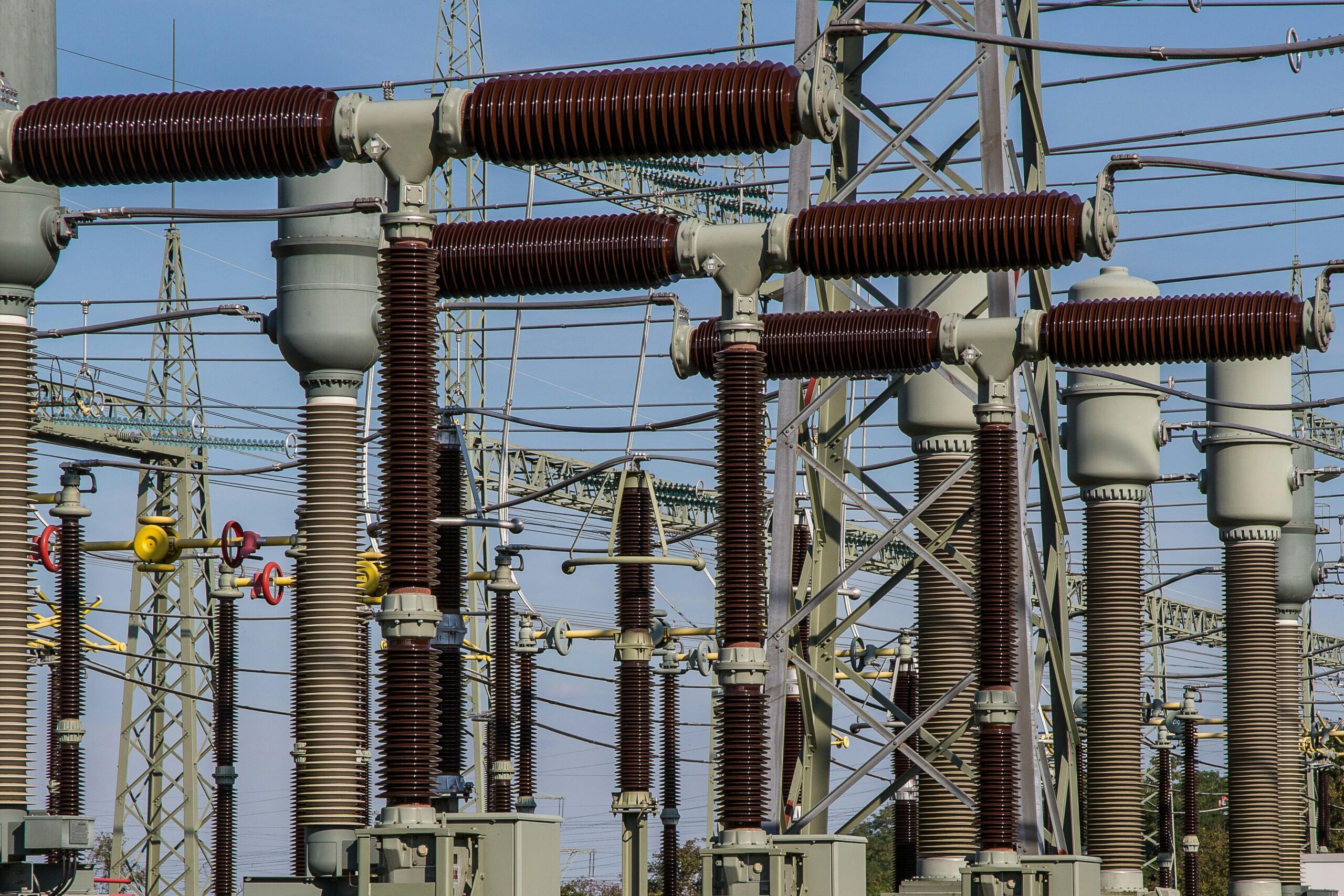 Several energy transformers before a blue sky.