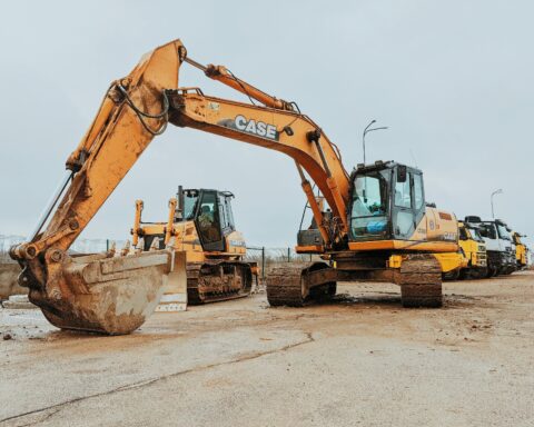 A construction vehicle sits next to another construction vehicle on a job site.