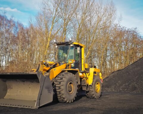 A construction vehicle next to a pile of dirt preparing for a capital project.
