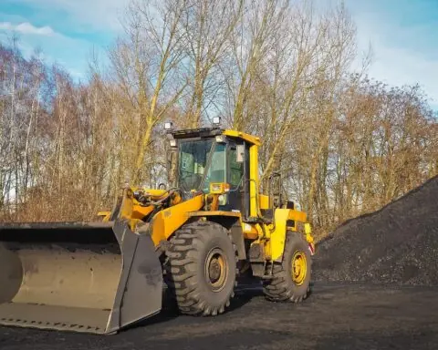 A construction vehicle next to a pile of dirt preparing for a capital project.