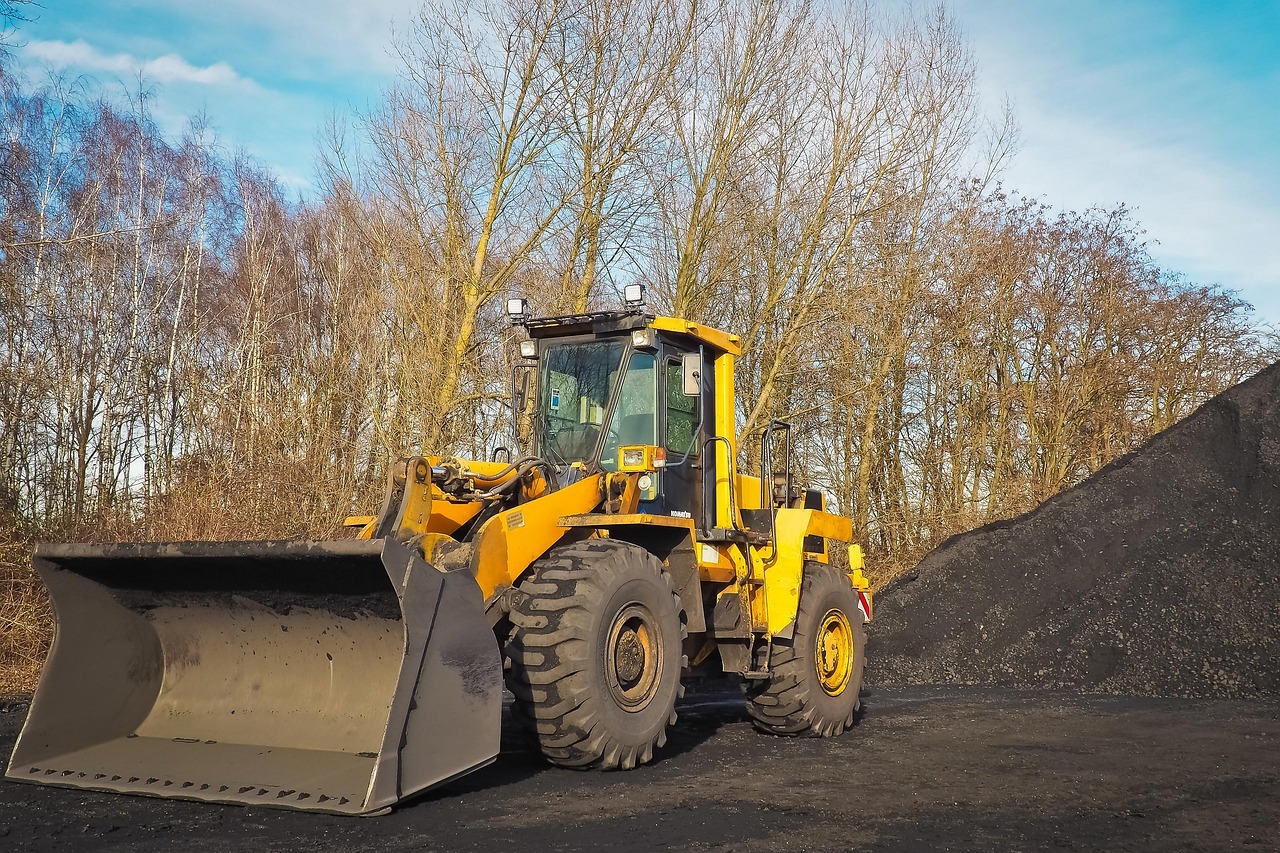 A construction vehicle next to a pile of dirt preparing for a capital project.