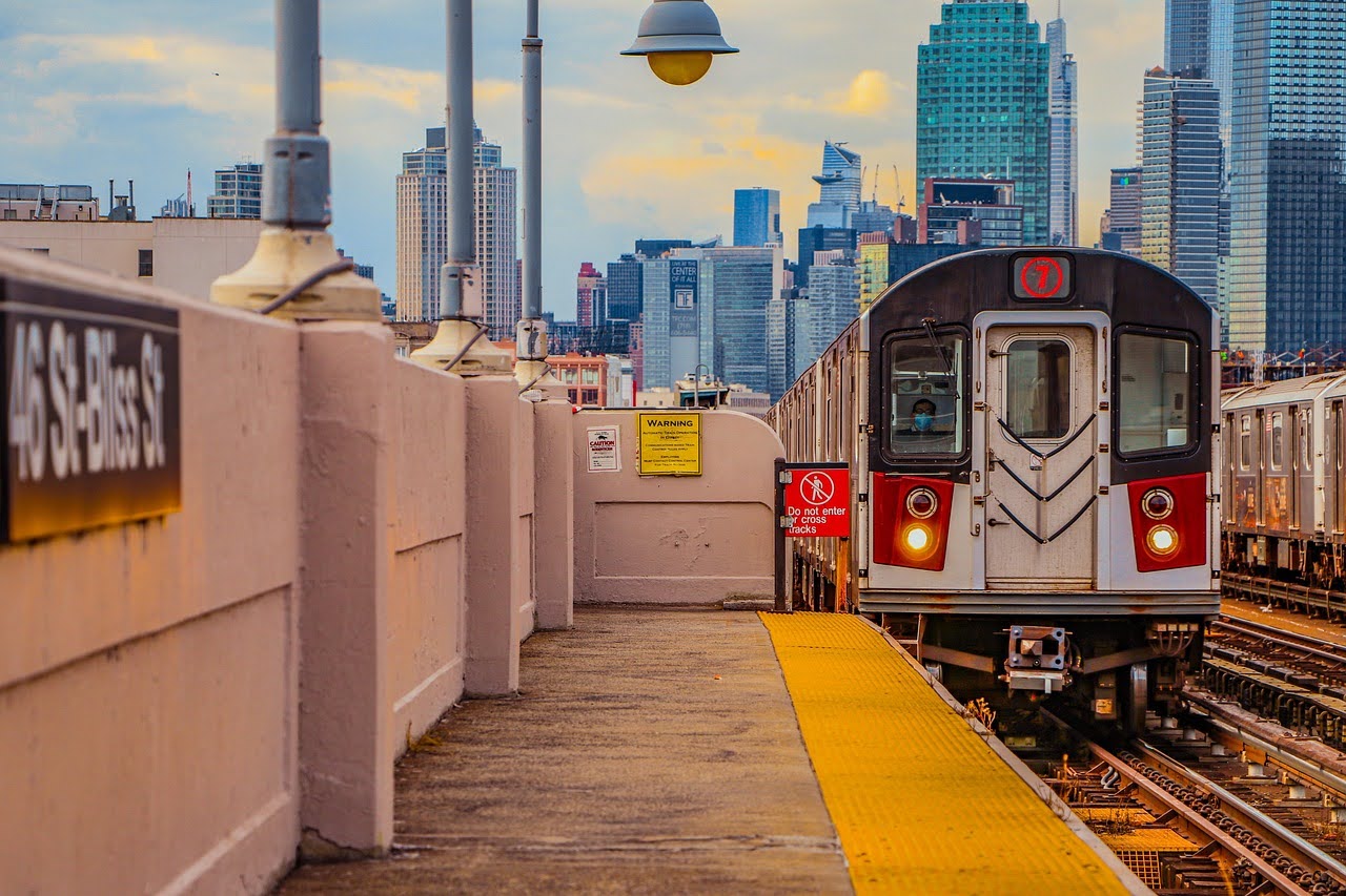 An MTA train in New York City approaches a pedestrian platform.