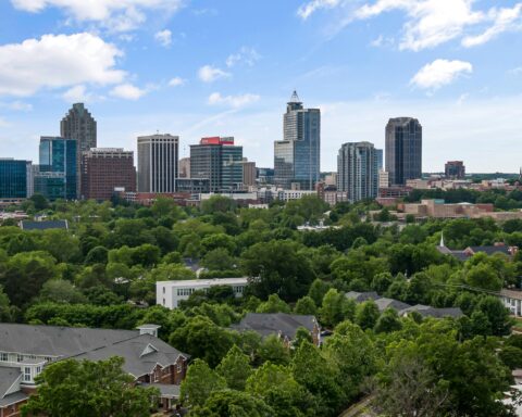 The image depicts Raleigh's skyline in North Carolina during the day.