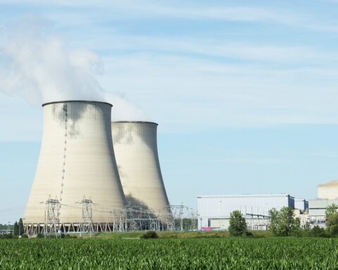 Nuclear silos in the distance above a grassy field.
