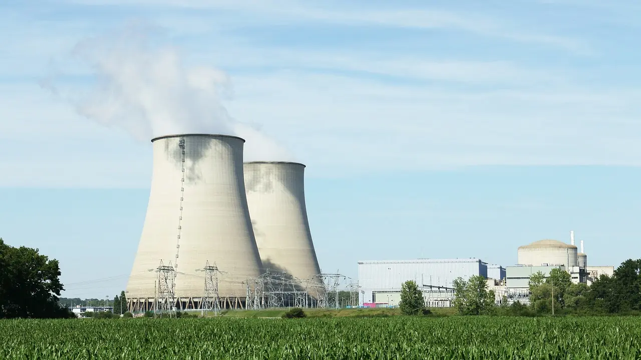 Nuclear silos in the distance above a grassy field.