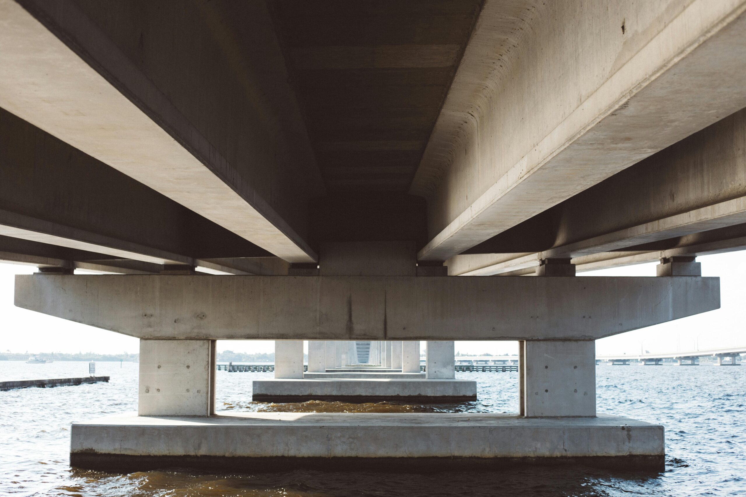 The underside of a bridge above water.