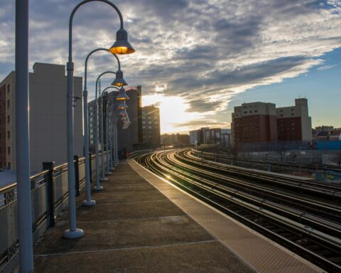 A set of railroad tracks underneath a bright sun.