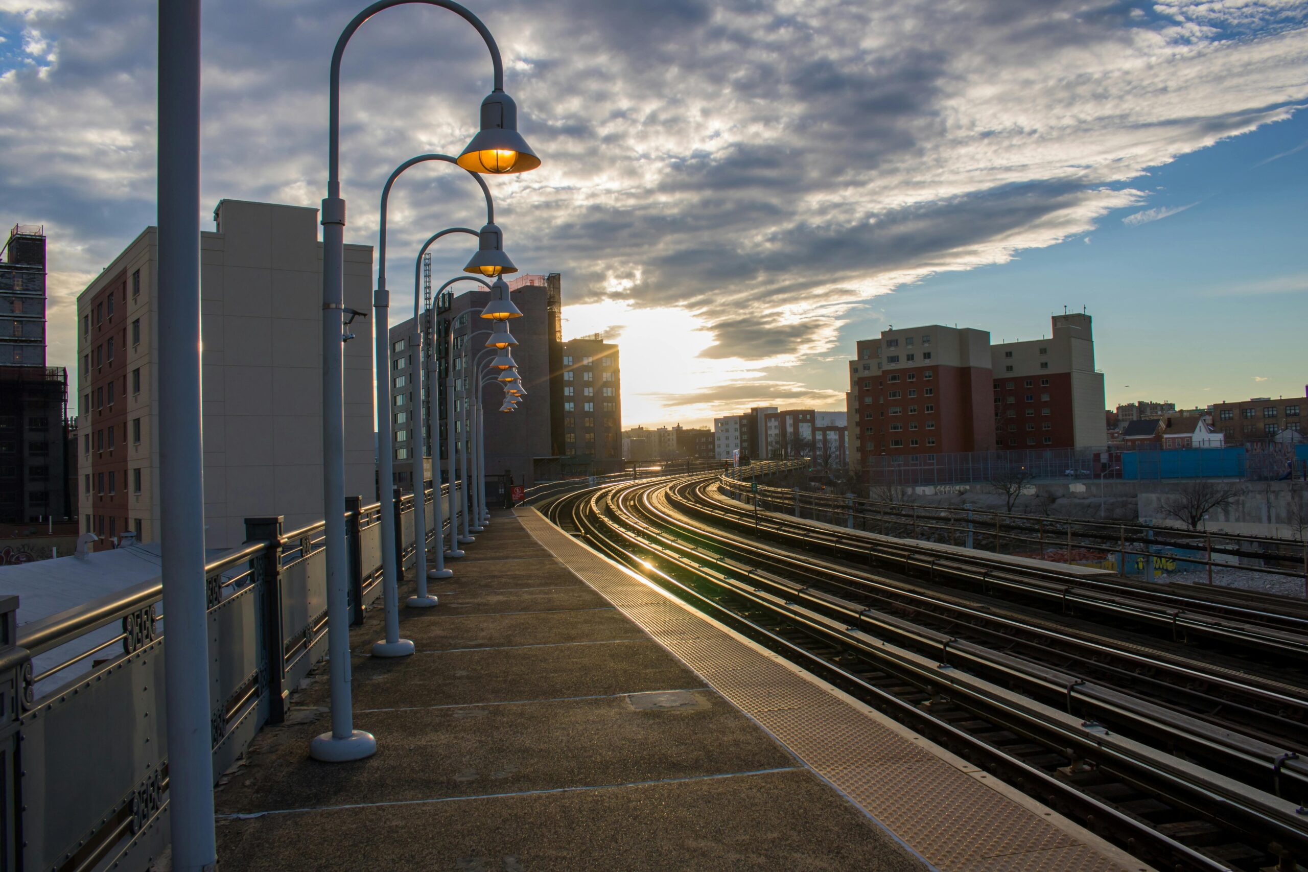 A set of railroad tracks underneath a bright sun.