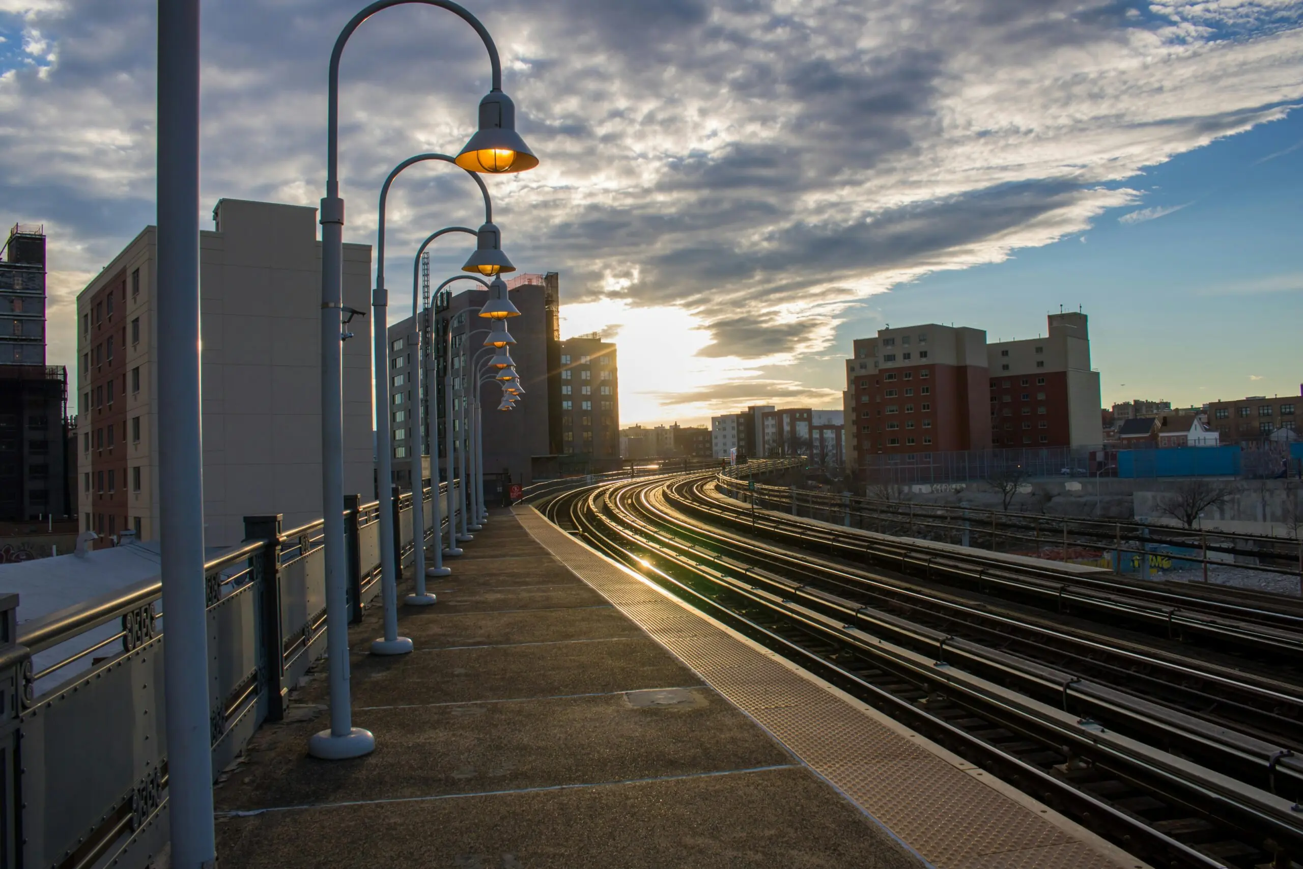 A set of railroad tracks underneath a bright sun.