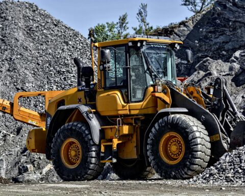 A construction vehicle on rocks and gravel moving materials.