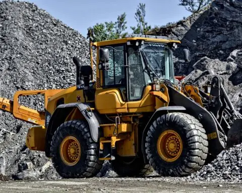 A construction vehicle on rocks and gravel moving materials.