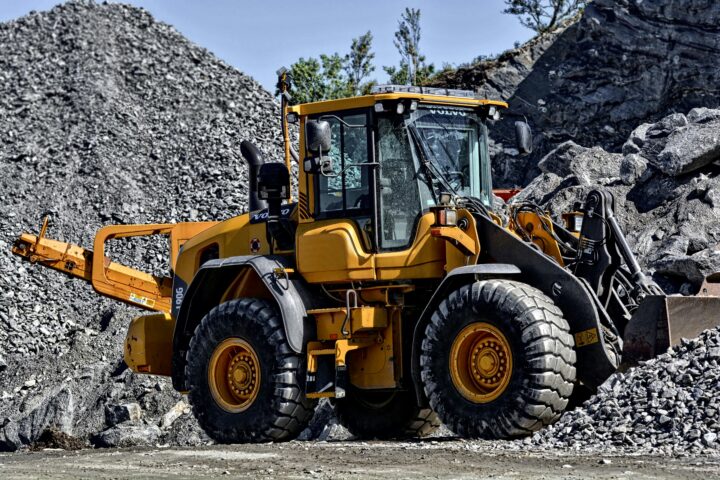 A construction vehicle on rocks and gravel moving materials.