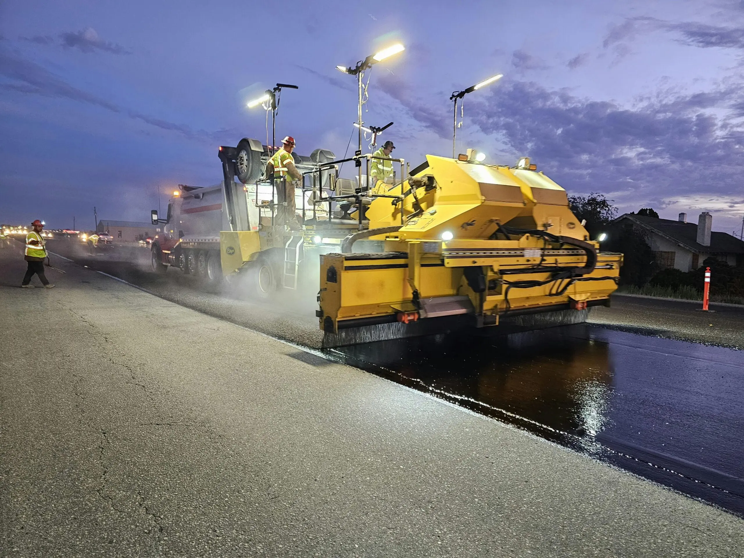A construction vehicle repaves a roadway.