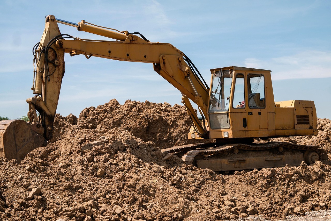 A construction vehicle on a work site on a pile of dirt.