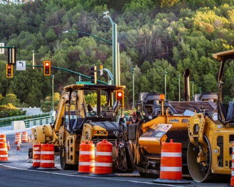 Construction vehicles line a road before construction.