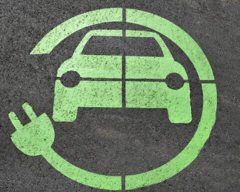 A symbol symbolizing a charging station for electric vehicles on asphalt.