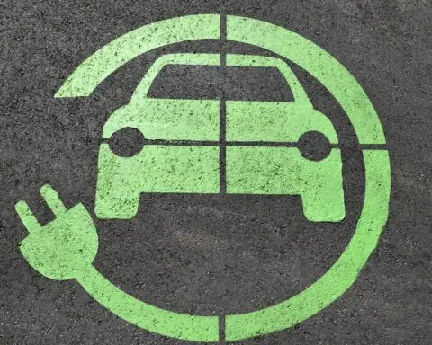 A symbol symbolizing a charging station for electric vehicles on asphalt.