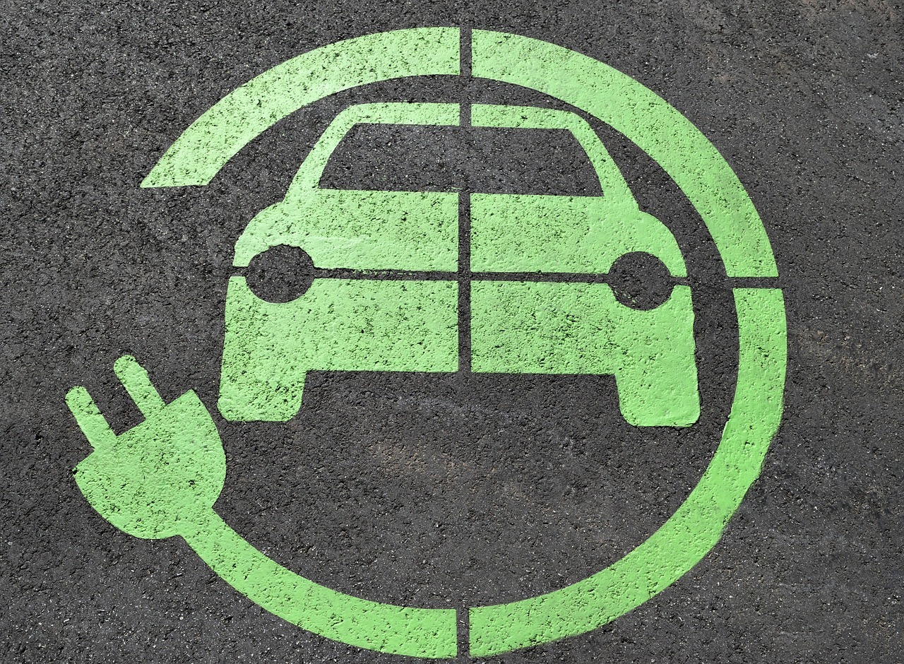 A symbol symbolizing a charging station for electric vehicles on asphalt.